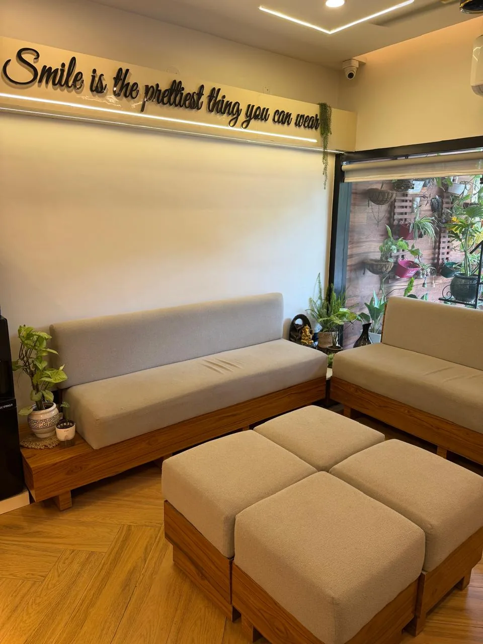 Comfortable waiting lounge at Poly Dental Clinic Mohali with 'a smile is the prettiest thing you can wear' wall art