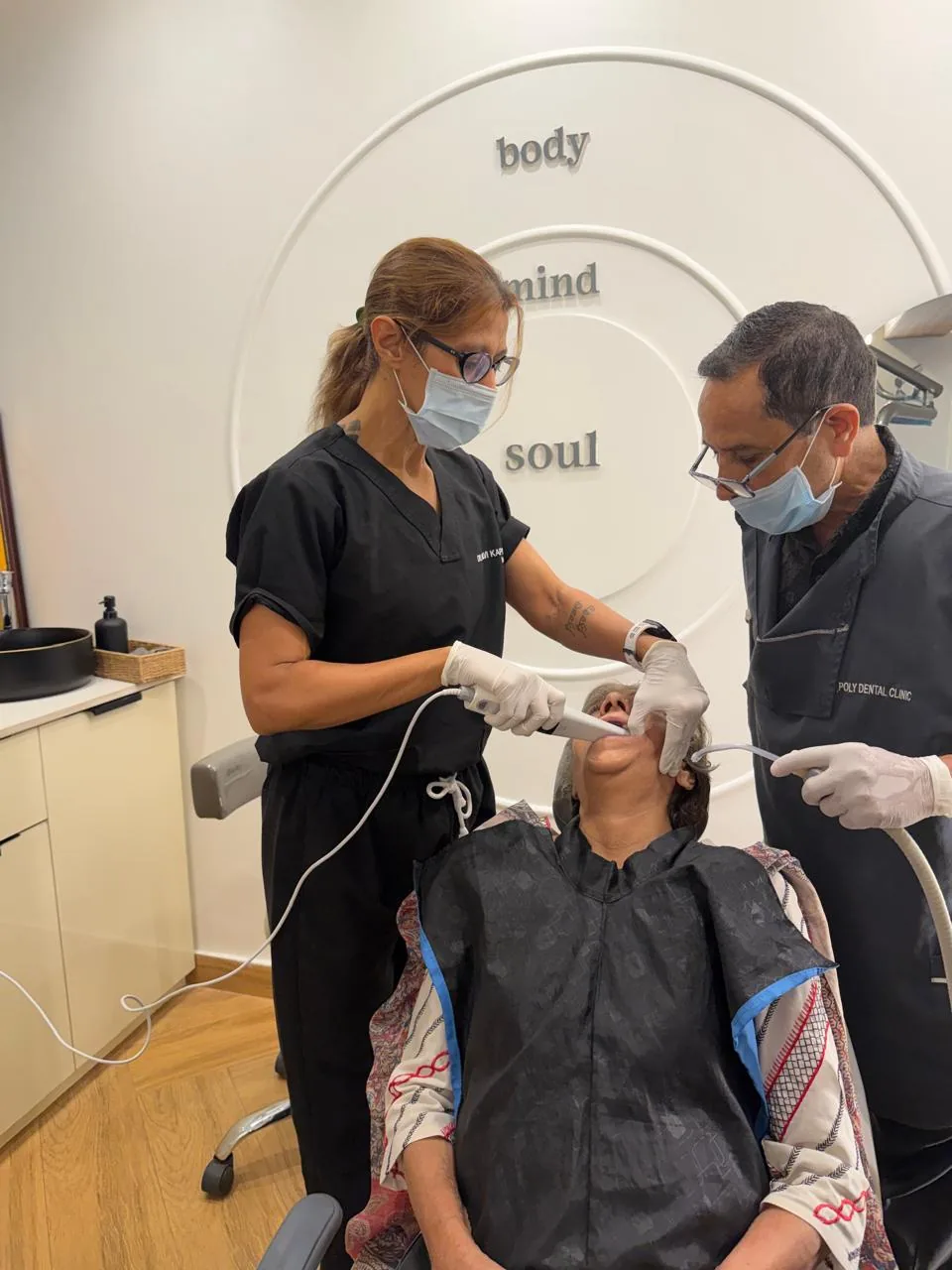 Dr. Palvi Kapoor and Dr. Dheeraj Kapoor treating a patient at Poly Dental Clinic Mohali